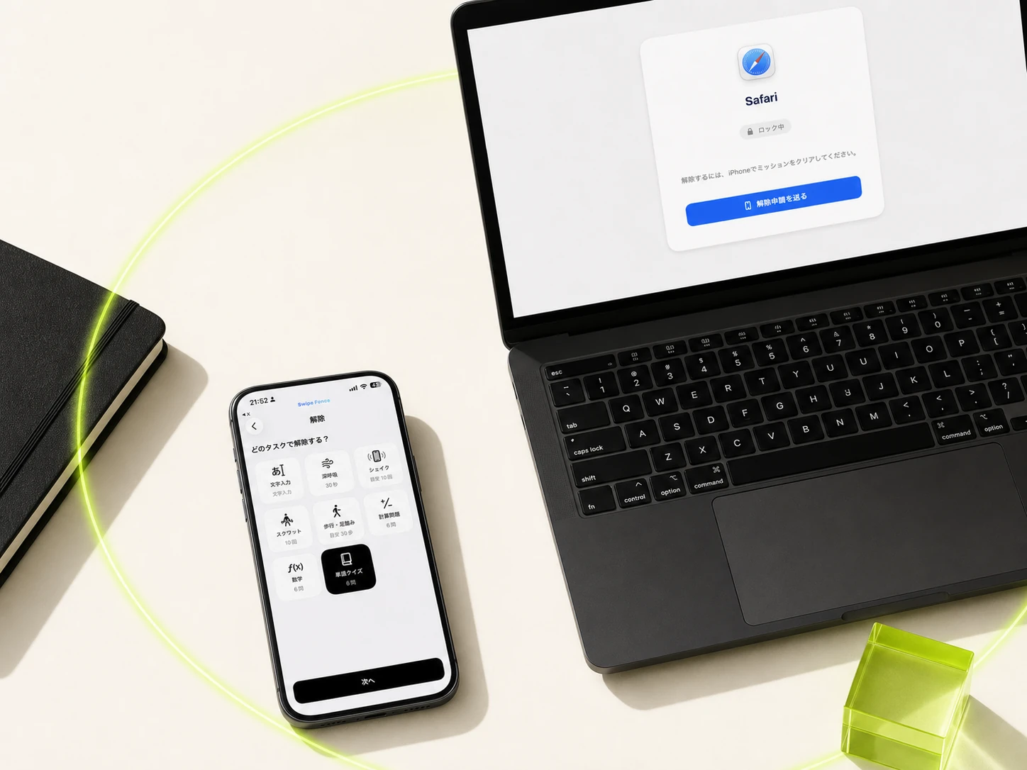 クリーム色の卓上に、Safariが「ロック中」と表示され「解除申請を送る」ボタンが出たMacBookと、8つの解除ミッションのタイルを表示したiPhoneが並ぶ。2台をライムの光の輪が囲み、右手前にライムのアクリルブロックが置かれている。